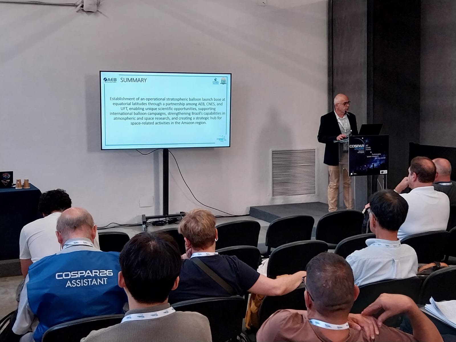 Diretor Leonardi à esquerda apresentando painel para a plateia.