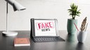 mesa-com-laptop-e-noticias-falsas.jpg