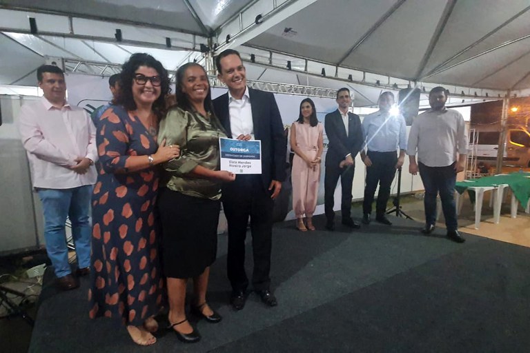 Diretor Vitor Saback e a secretária estadual Andréa Vulcanis entregam outorga à produtora rural Eliete Jorge