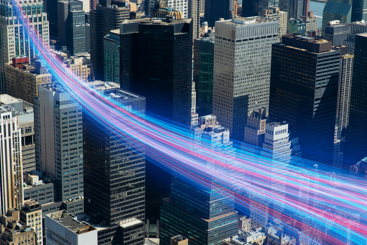 IMAGEM mostra cidade vista do alto com feixes de fibra óptica a percorrê-la