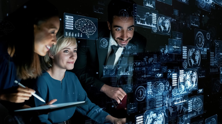 Pessoas reunidas diante de interfaces digitais com gráficos, mapas e elementos de inteligência artificial, representando a integração entre pesquisa, inovação tecnológica e apoio à tomada de decisões no ambiente regulatório.