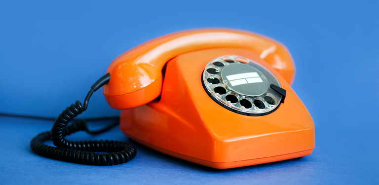 Telefone de disco laranja sobre fundo azul