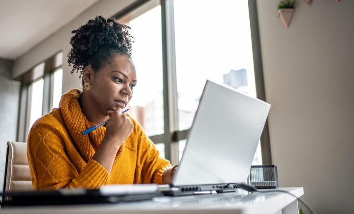 mulher observa computador com painel de dados da Anatel