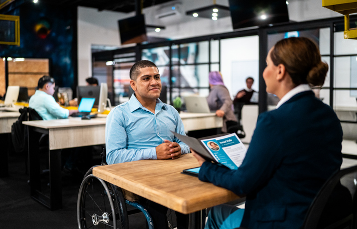 homem de cadeira de rodas em loja de empresa de telefonia