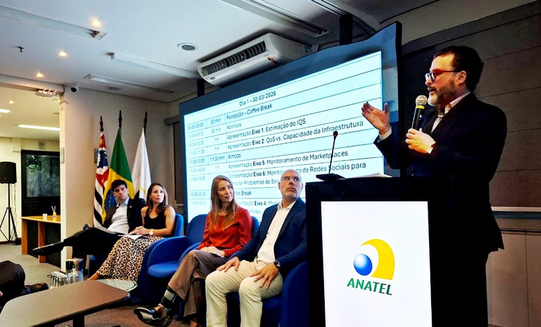 Pessoas participam de seminário. Algumas delas estão sentadas enquanto uma pessoa faz uma apresentação.