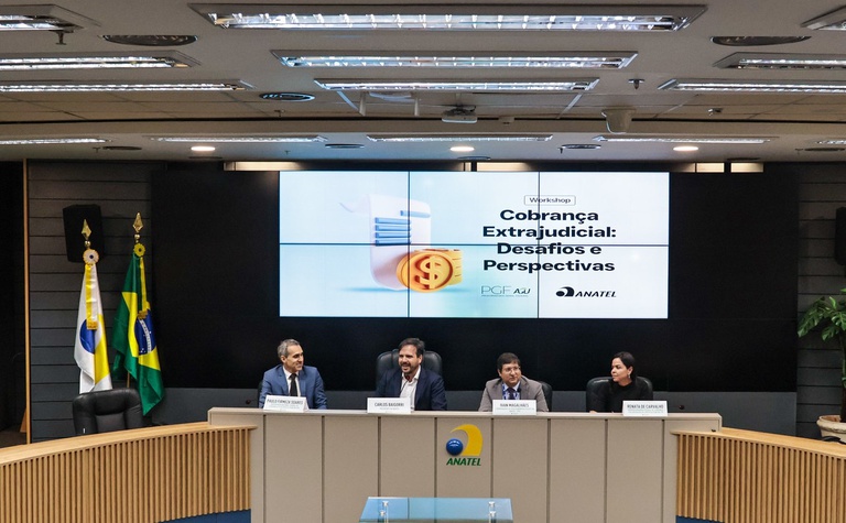 Imagem da Sala do Conselho Diretor da Anatel com quatro pessoas sentadas à mesa