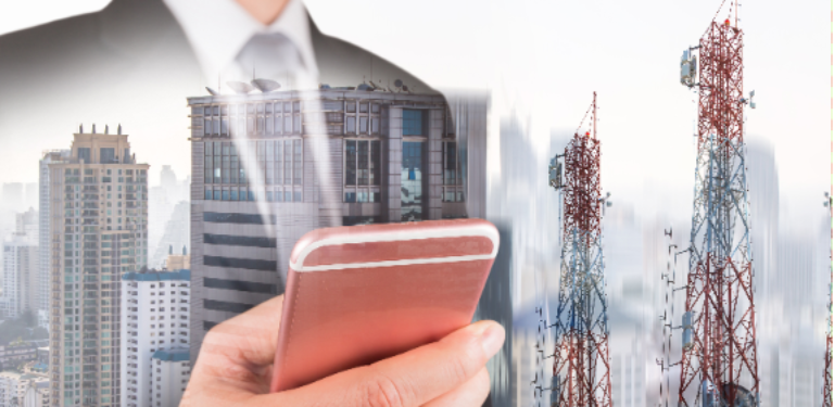 Homem com celular e antenas móveis ao fundo