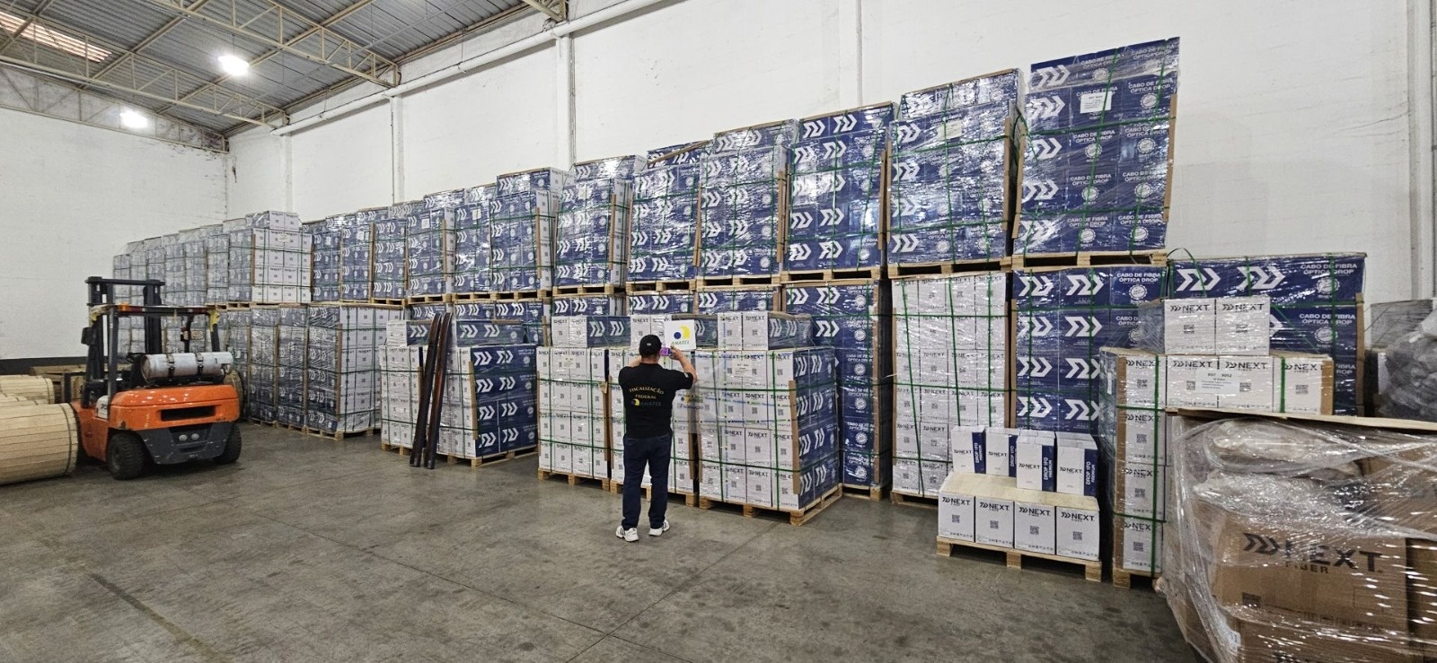 homem inspeciona caixas com cabos de fibra óptica