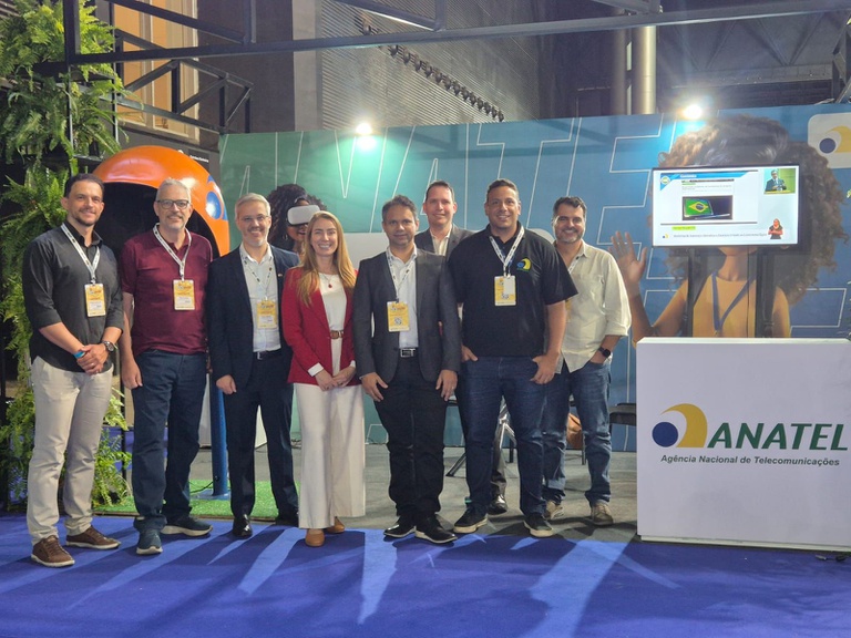 Imagem mostra grupo de servidores da Anatel em frente ao estande