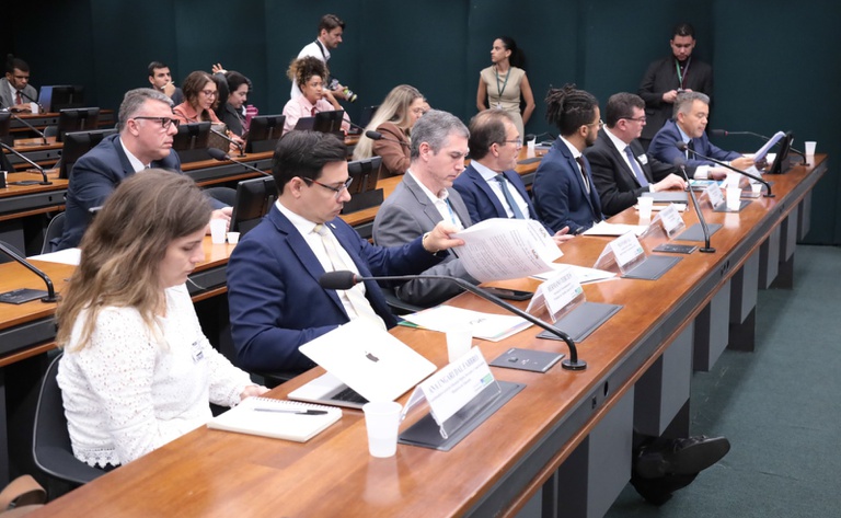 Mesa com seis integrantes durante audiência pública em plenário da Câmara dos Deputados