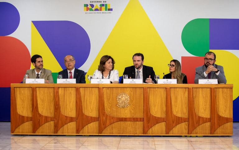 imagem mostra autoridades em bancada durante entrevista coletiva à imprensa