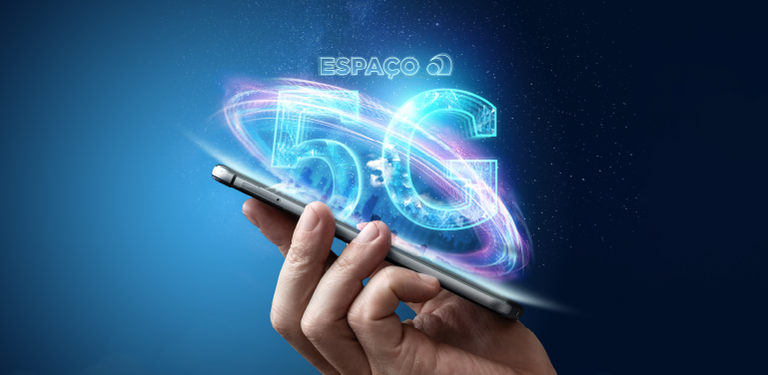 Em uma imagem em tons azulados, uma mão segura um celular do qual saem da tela a inscrição Espaço 5G
