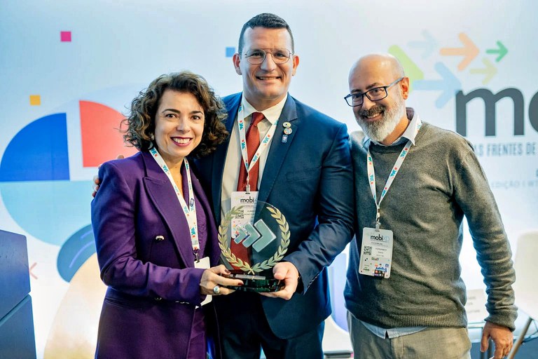 Patrícia Coutinho e Humberto Pontes, da Anatel, recebem o prêmio de Fernando Paiva, diretor do Mobile Time