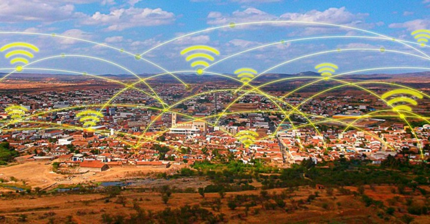 A imagem representa uma cidade pequena ou média digitalmente conectada, destacando a expansão do acesso à internet.