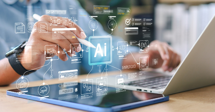 Pessoa interage com tablet e notebook sobre uma mesa, enquanto elementos gráficos digitais relacionados à inteligência artificial aparecem sobrepostos à imagem. No centro, destaca-se o símbolo “AI”, conectado a ícones e painéis que representam análise de documentos, automação, processamento de informações e integração de dados, ilustrando o uso de IA para apoio a atividades digitais e gestão de processos.