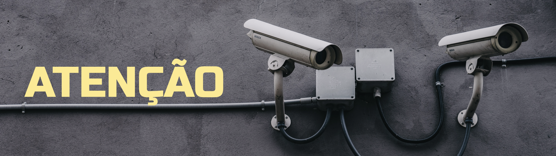 Imagem de câmeras de monitoramento instaladas sobre parede cinza escura. Em amarelo, o texto diz 