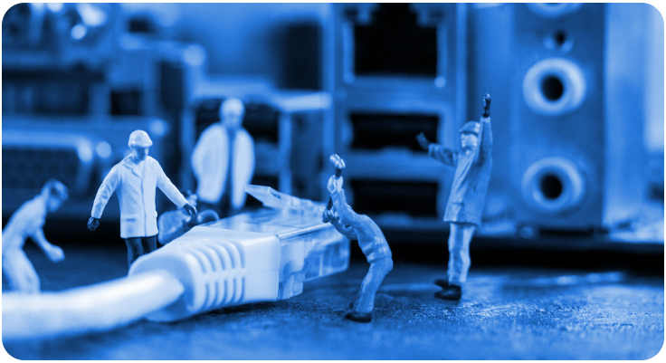 Bonecos minúsculos representando homens conectando um cabo de rede a um computador