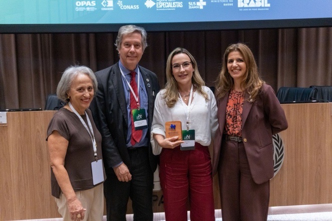 A gerente de Padronização, Interoperabilidade e Análise de Informações e Desenvolvimento Setorial da ANS, Juliana Machado, recebe homenagem em nome da Agência