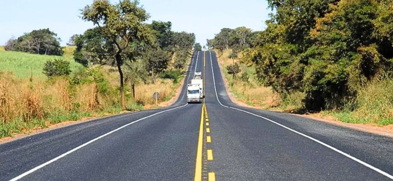 IMAGEM DA RODOVIA COM CARROS E AREA VERDE AO LADO