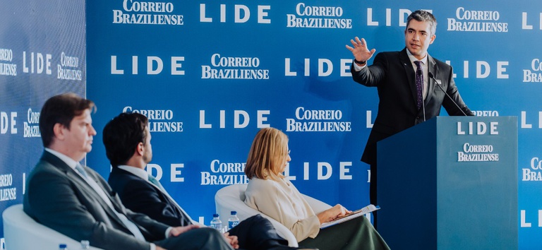 IMAGEM DE TRES PESSOAS SENTADAS E UM EM PÉ