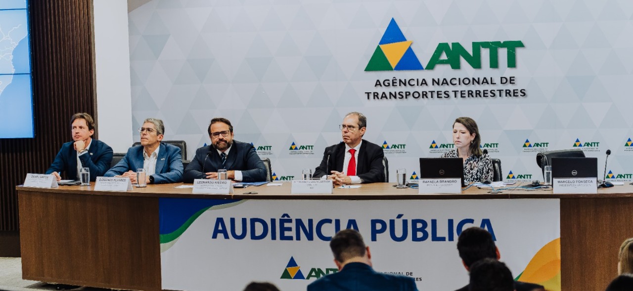 IMAGEM DA AUDIENCIA COM SETE PESSOAS ATRAS DA MESA