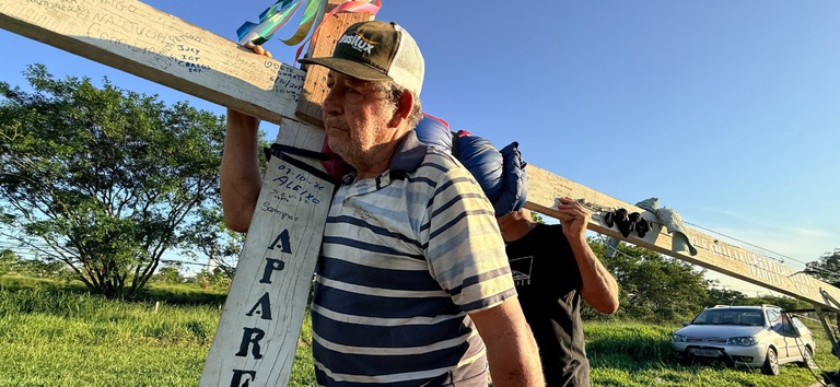 IMAGEM DE UM HOMEM CARREGANDO UMA CRUZ DE MADEIRA