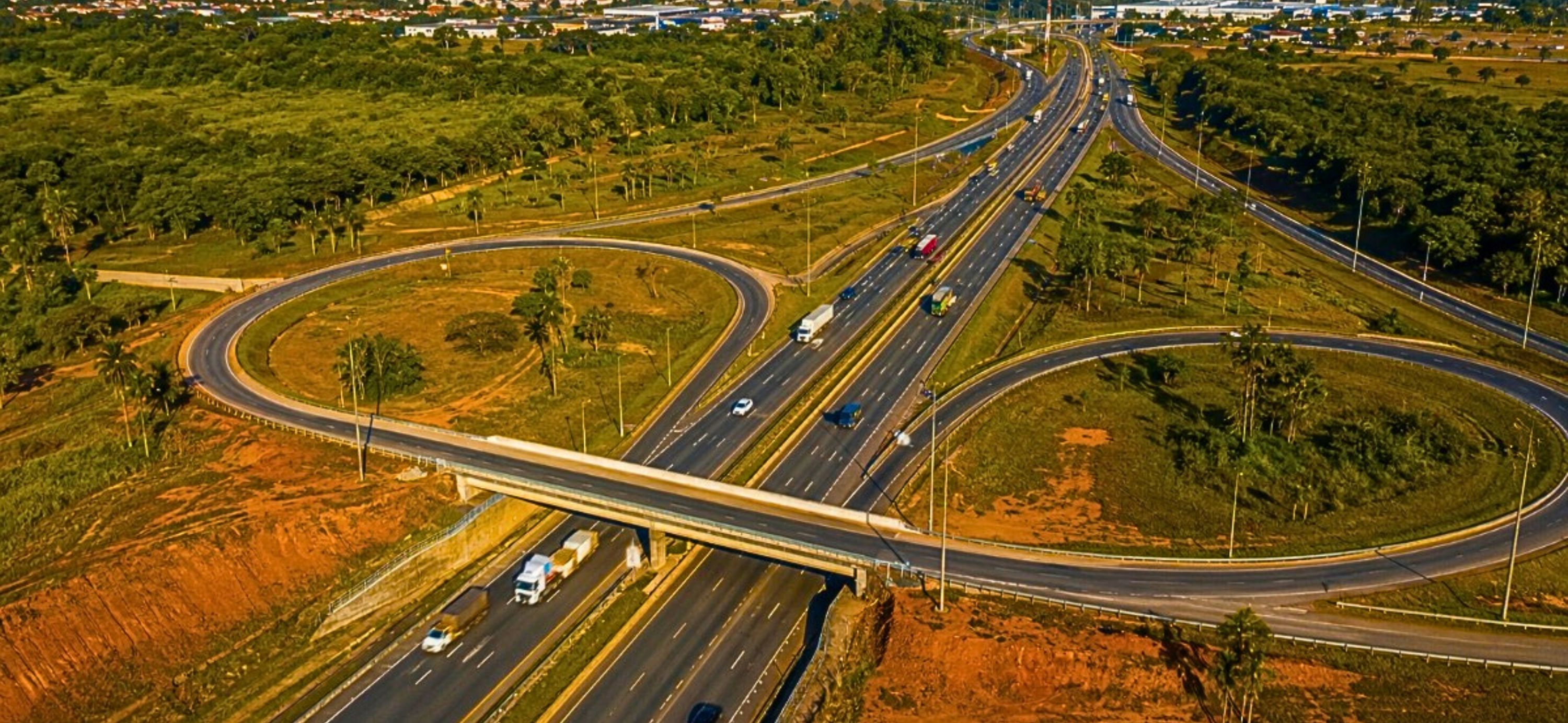 IMAGEM DA RODOVIA COM CARROS E AREA VERDE AO LADO