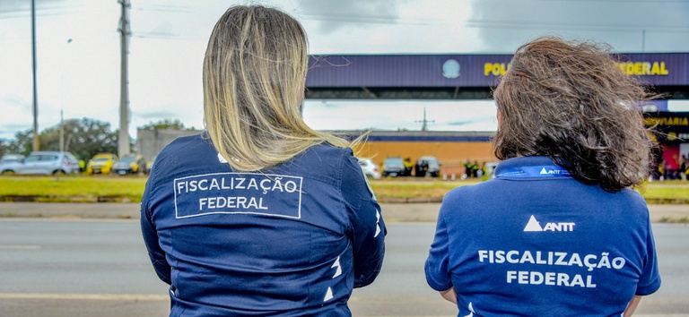 IMAGEM DE DUAS MULHERES NA RODOVIA COM UNIFORMES DA ANTT