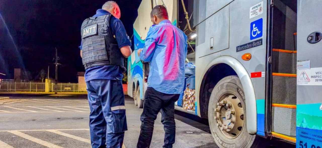 IMAGEM COM DOIS HOMENS DE FRENTE PARA UM ONIBUS