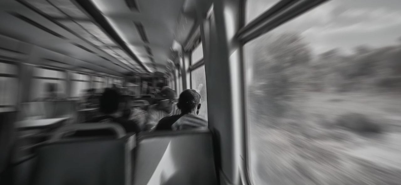 IMAGEM COM UMA PESSOA SENTADA NO METRO E COM VARIAS CADEIRAS