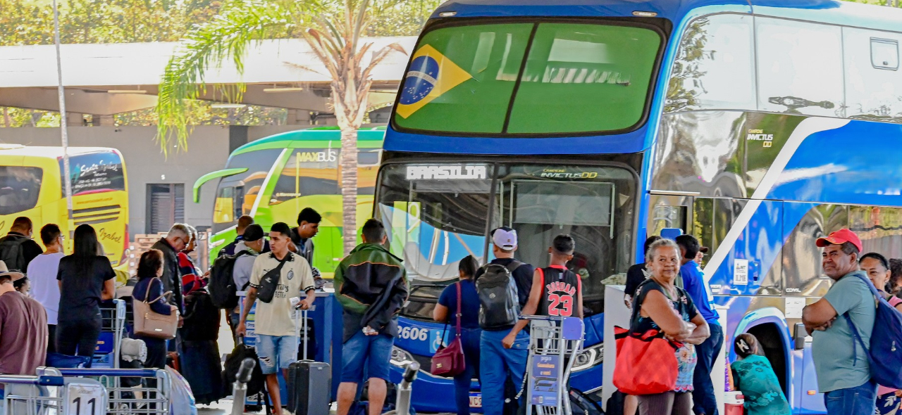 IAMGEM NA RODOVIARIA COM PESSOAS NA FILA PARA ENTRAR NO ONIBUS