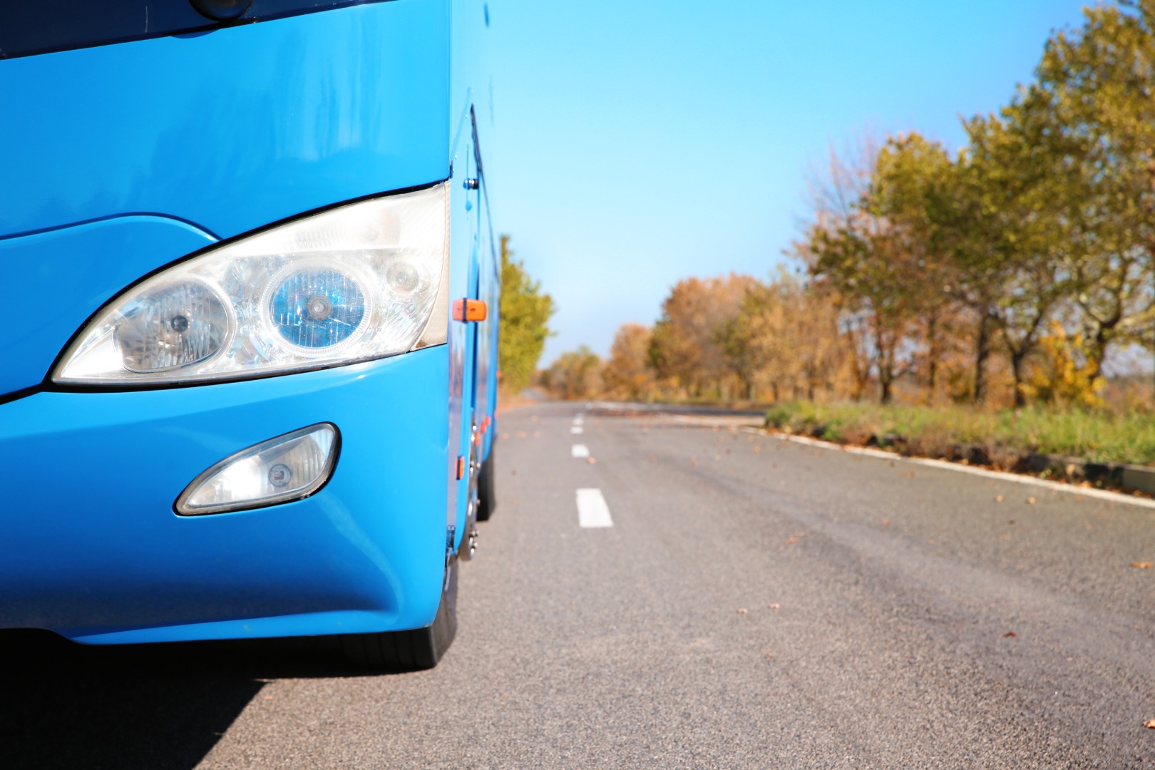 modern-blue-bus-on-road-focus-on-headlight-passe-2026-03-27-02-25-21-utc.jpg
