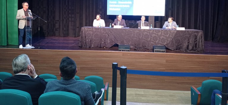 Foto da audiência pública em Tubarão, mostrando parte do auditório e os membros da mesa