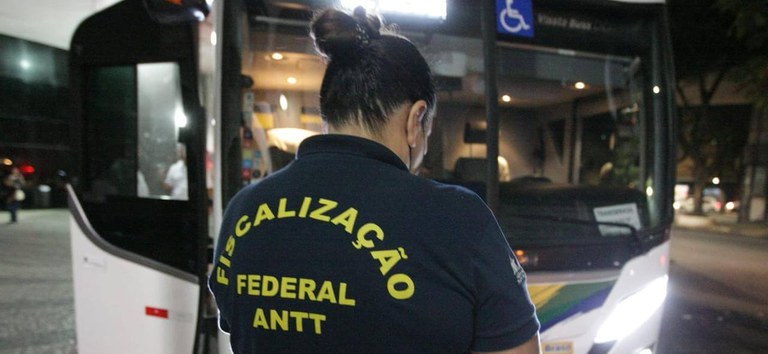 Fiscal da ANTT, com uniforme, fiscalizando ônibus interestadual