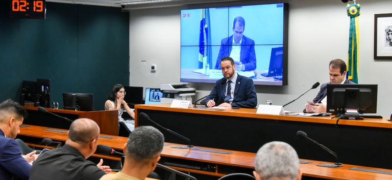 IMAGEM DE DOIS HOMENS SENTADOS ATRÁS DA MESA
