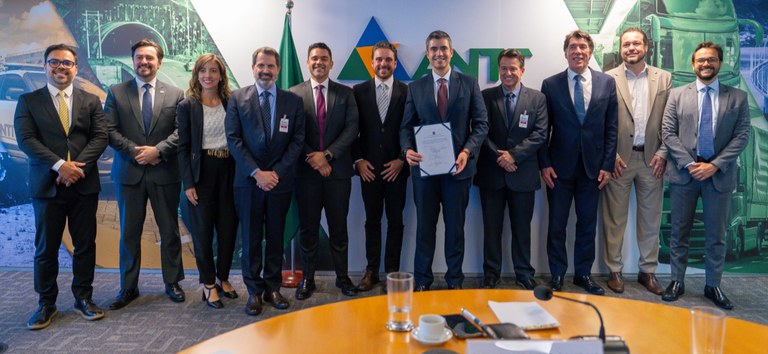 Foto mostrando a diretoria da ANTT e da concessionária com o ato do termo aditivo assinado