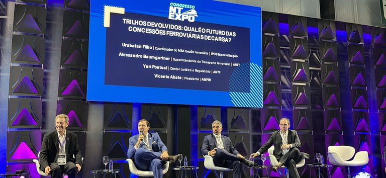 Foto com participantes e superintendente da ANTT no palco palestrando