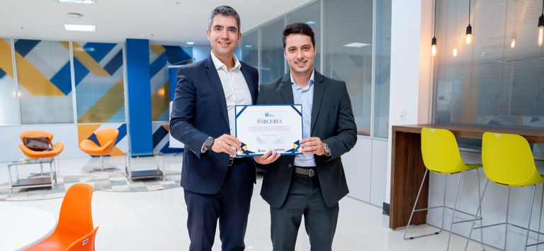 Diretores-gerais da ANTT e ARTEMIG segurando o termo de parceria do Coopera