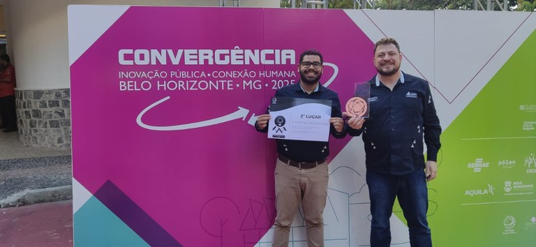 Foto mostrando membros da ANTT segurando o certificado e o troféu da premiação