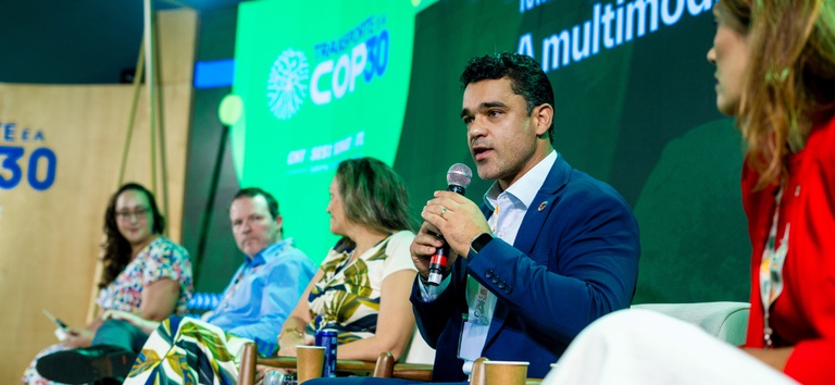 Foto com diretor Felipe Queiroz em painel da COP 30