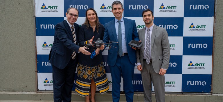 Foto mostrando autoridades da ANTT e da Rumo segurando caixa com drone profissional