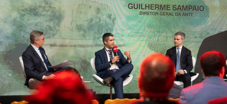 Foto mostrando o diretor-geral da ANTT, Guilherme Theo Sampaio, ao lado de jornalistas no CNN Talks