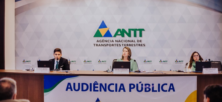 IMAGEM COM TRES PESSOAS SENTADAS DE TRAZ DE UMA BANCADA