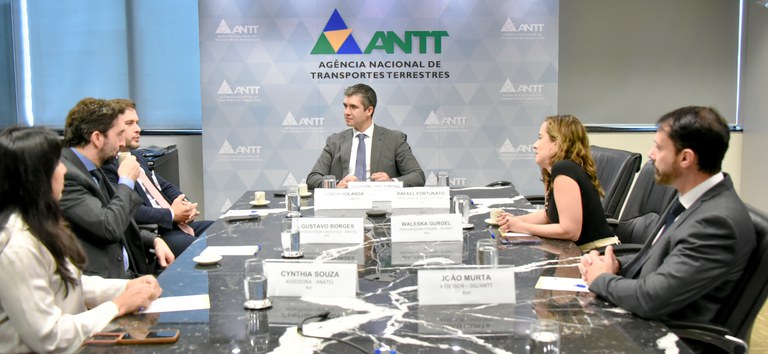 Foto mostrando diretor e representantes da ANTT e Anatel na reunião
