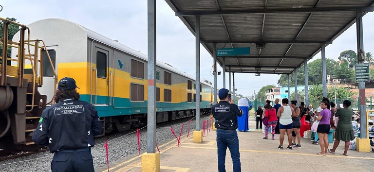IMAGEM COM AGENTES DA ANTT E UM TREM ATRÁS