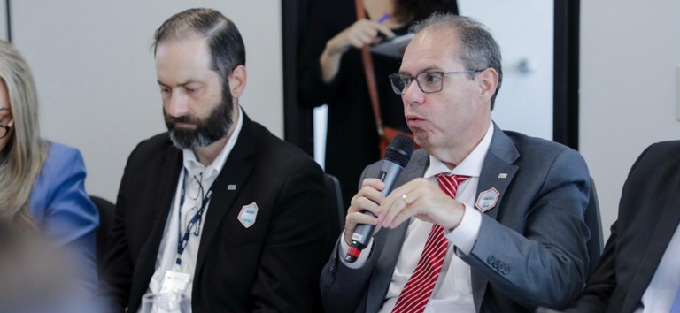 Foto mostrando diretor Alessandro na mesa em debate com a FRENELOGI
