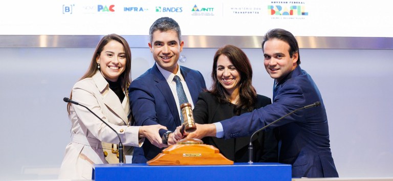 Foto com o diretor-geral da ANTT e equipe da agência batendo martelo no leilão