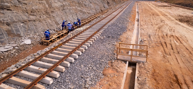 Foto mostrando trilhos e obras na ferrovia com os trabalhadores atuando