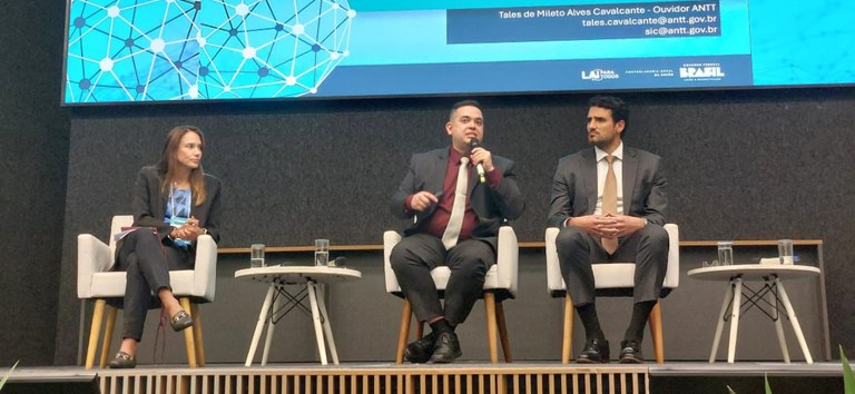 Foto mostrando ouvidor da ANTT, ao lado de outras autoridades, apresentando cases da Agência no encontro RedeSIC