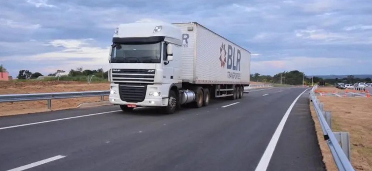 Foto mostrando caminhão de cargas trafegando em rodovia federal concedida